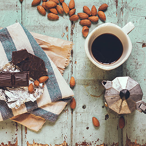 dark chocolate, almonds, and fresh coffee on a table